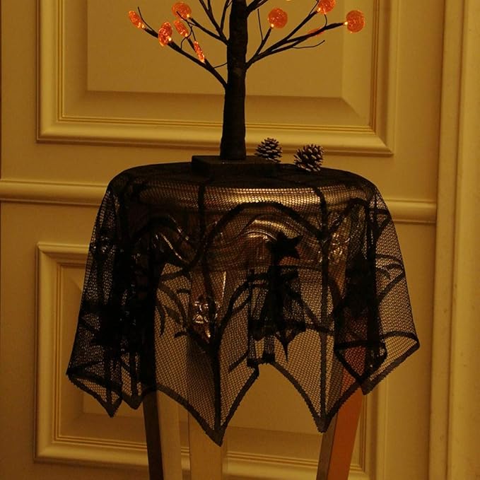 Black spider web table cover with bats and stars design over a round table