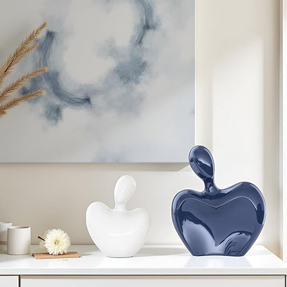 Blue and white ceramic abstract hugging couple figurines with heart forms and glossy glaze.