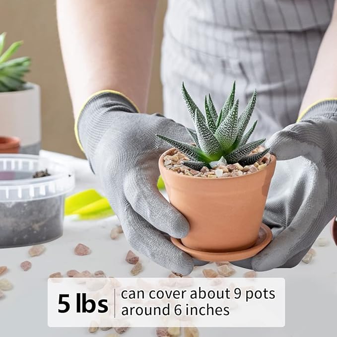 Peach-colored natural stone pebbles being placed into a small terracotta pot