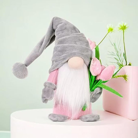 Standing grey plush gnome with white beard, pink clothing, and tulip flower bunch