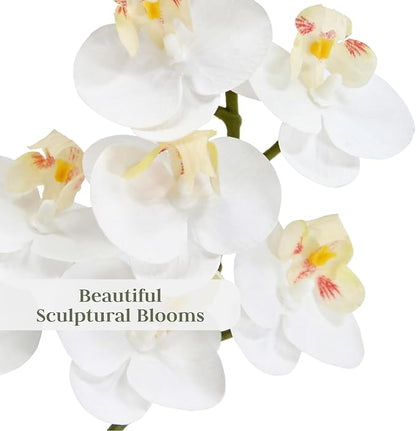 Close-up faux white orchid blossoms with soft yellow centers and green stems