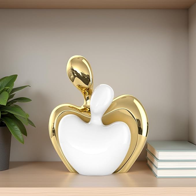 White and gold ceramic couple figurine with abstract heart shape on tabletop shelf