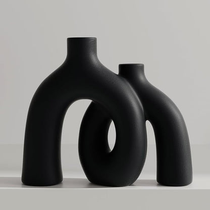 Matte black ceramic hug vase with conjoined donut-like bodies and open center cutouts