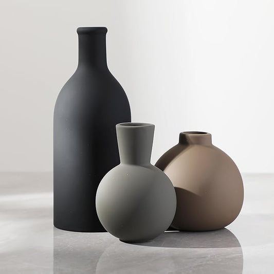 Set of 3 ceramic vases in matte black, taupe, and off-white with rounded bottle shapes.
