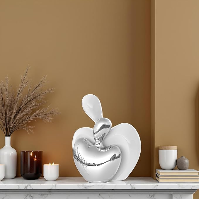 White and silver ceramic hugging couple heart figurine, sculpted romantic decor.