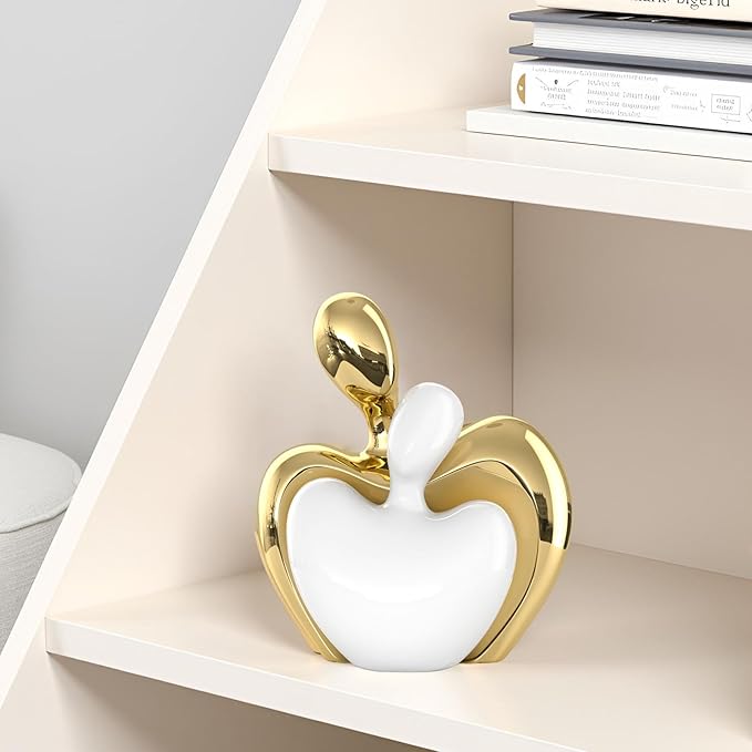 White and gold ceramic couple figurine on a shelf, abstract heart with hugging pose