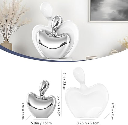 Abstract white and silver ceramic couple figurines forming a heart, hugging pose.