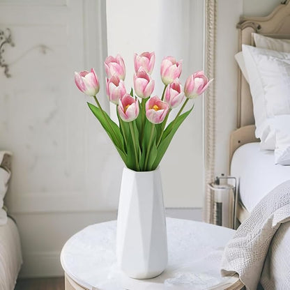 Pink faux tulip stems in a white vase on a table