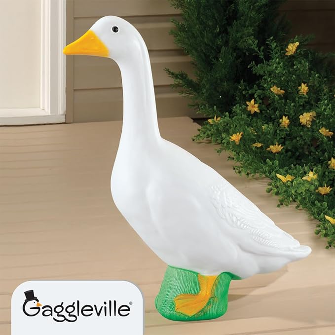 White porch goose statue with yellow beak and feet on a green base