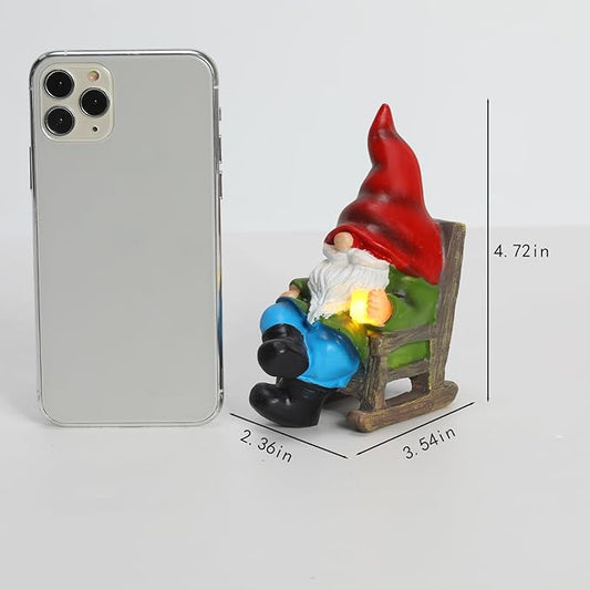 Garden gnome solar light statue on wooden chair, red cap and blue clothing with glowing lamp