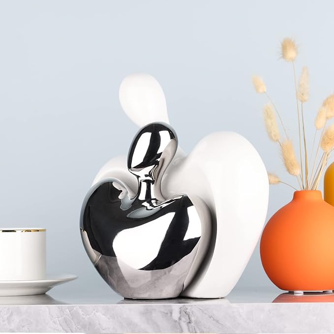 Abstract white and silver ceramic couple figurine, hugging heart silhouette.