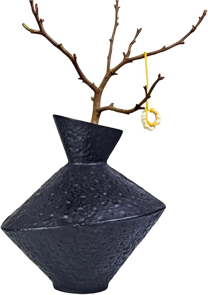 Dark hammered cast iron vase with angled neck and wide base, wabi-sabi style