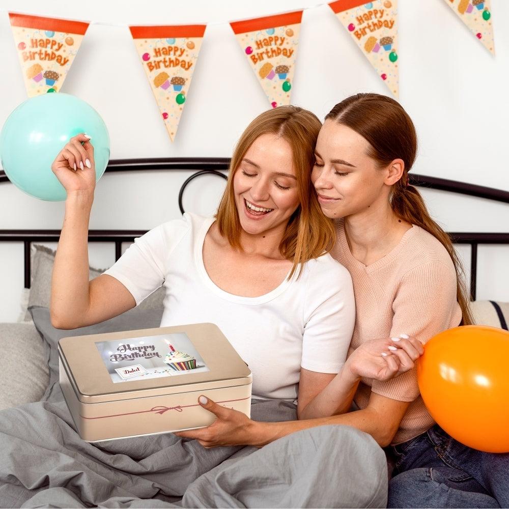 Deluxe Birthday Celebration Gift Tin gift box on lap with balloons