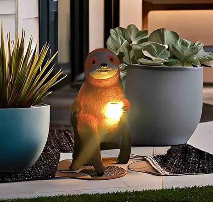 Solar light sloth garden figurine with warm glowing belly, standing on small mat.