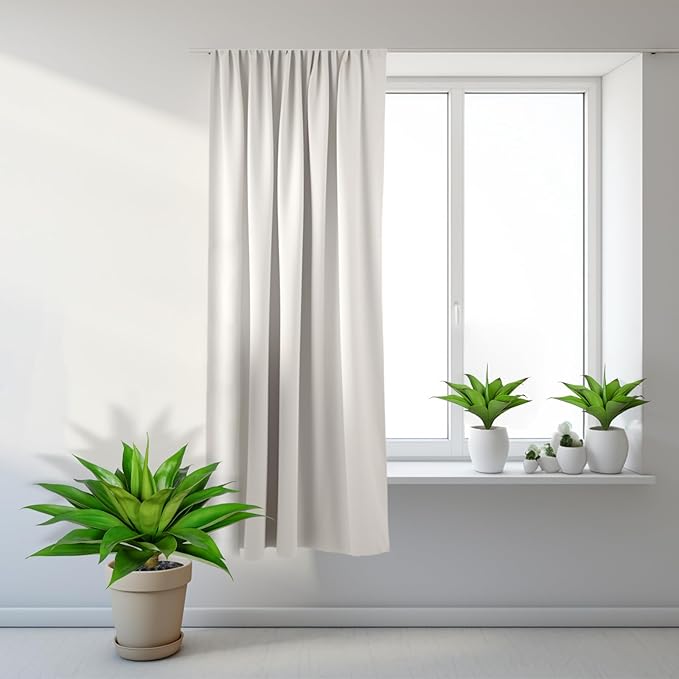Artificial green agave plants in white pots near window and on floor