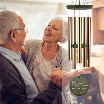 Gold wind chime with dark green round disc reading 20 years down