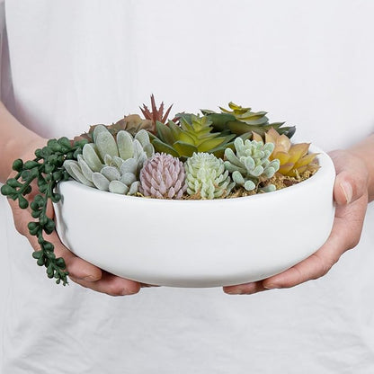 Hands holding a white concrete bowl filled with faux succulents and string-of-pearls