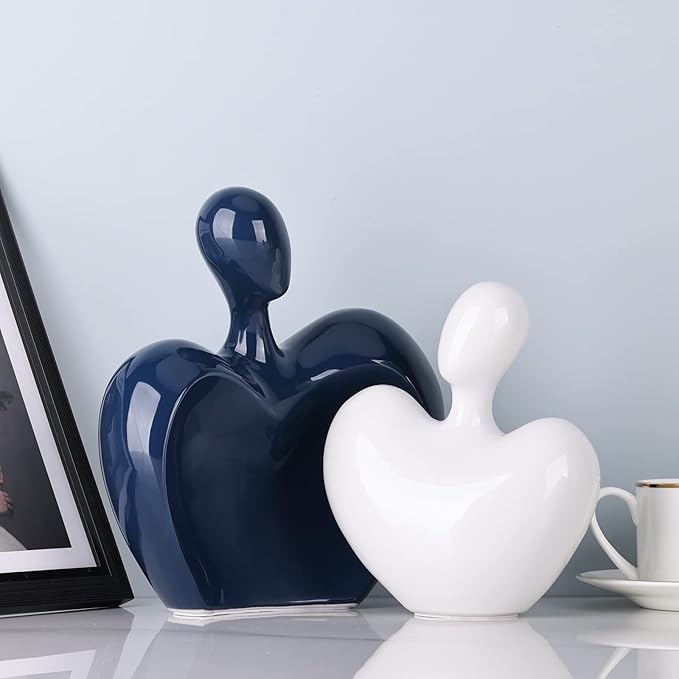 Blue and white ceramic abstract couple figurines, glossy hugging heart shapes facing left.