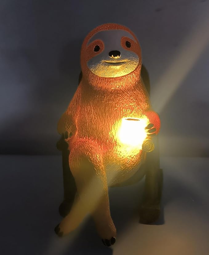 Solar light sloth figurine with warm glowing belly, close-up front view.