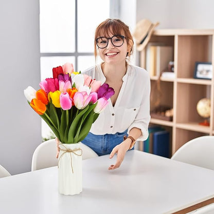 Artificial tulip bouquet with multicolor blooms in white vase tied with twine, held indoors