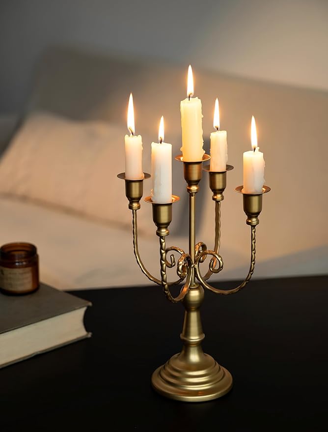 Gold 5-arm metal candelabra with five lit taper candles on a pedestal base