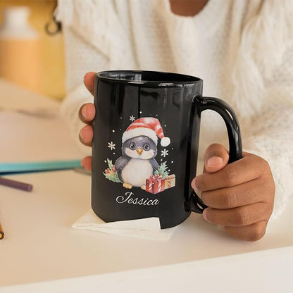 Black ceramic mug with penguin Santa hat design and name Jessica, held in hands