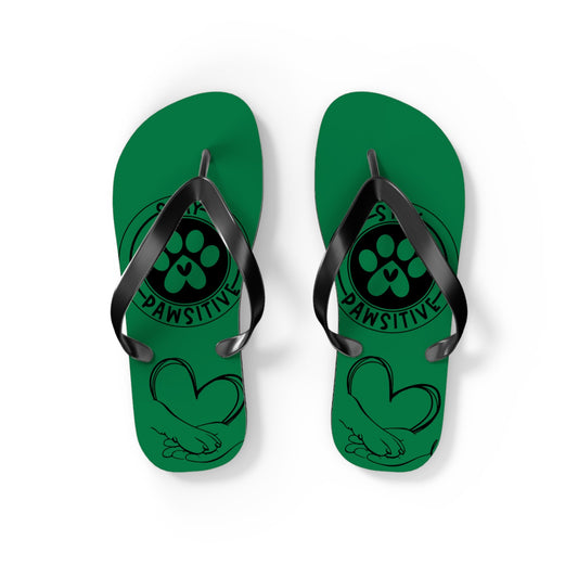 Pair of green flip-flops with black toe straps and paw-print artwork with “PAWSITIVE”