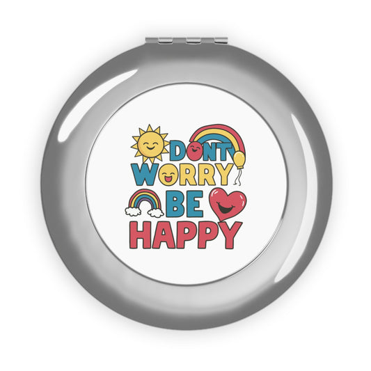 Silver glossy compact travel mirror with “DON'T WORRY BE HAPPY” printed on cover
