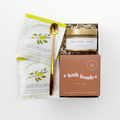 Spa gift set box with bath bomb, white lemon ginger tea packets, and wooden scoop