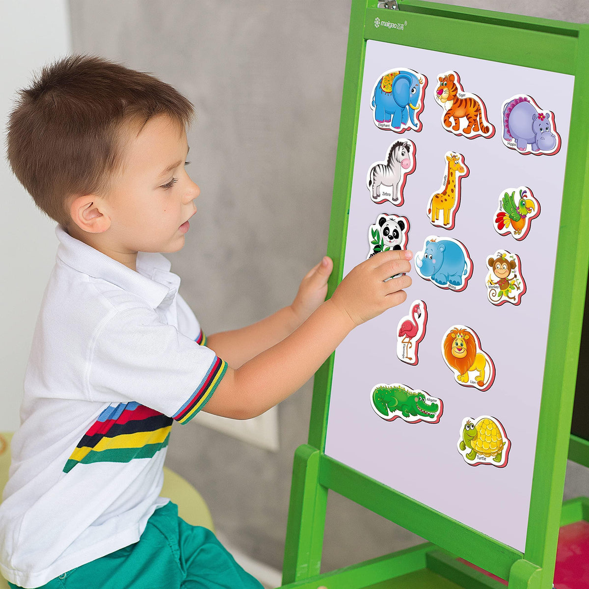 Child placing colorful zoo animal magnets on a green magnetic board