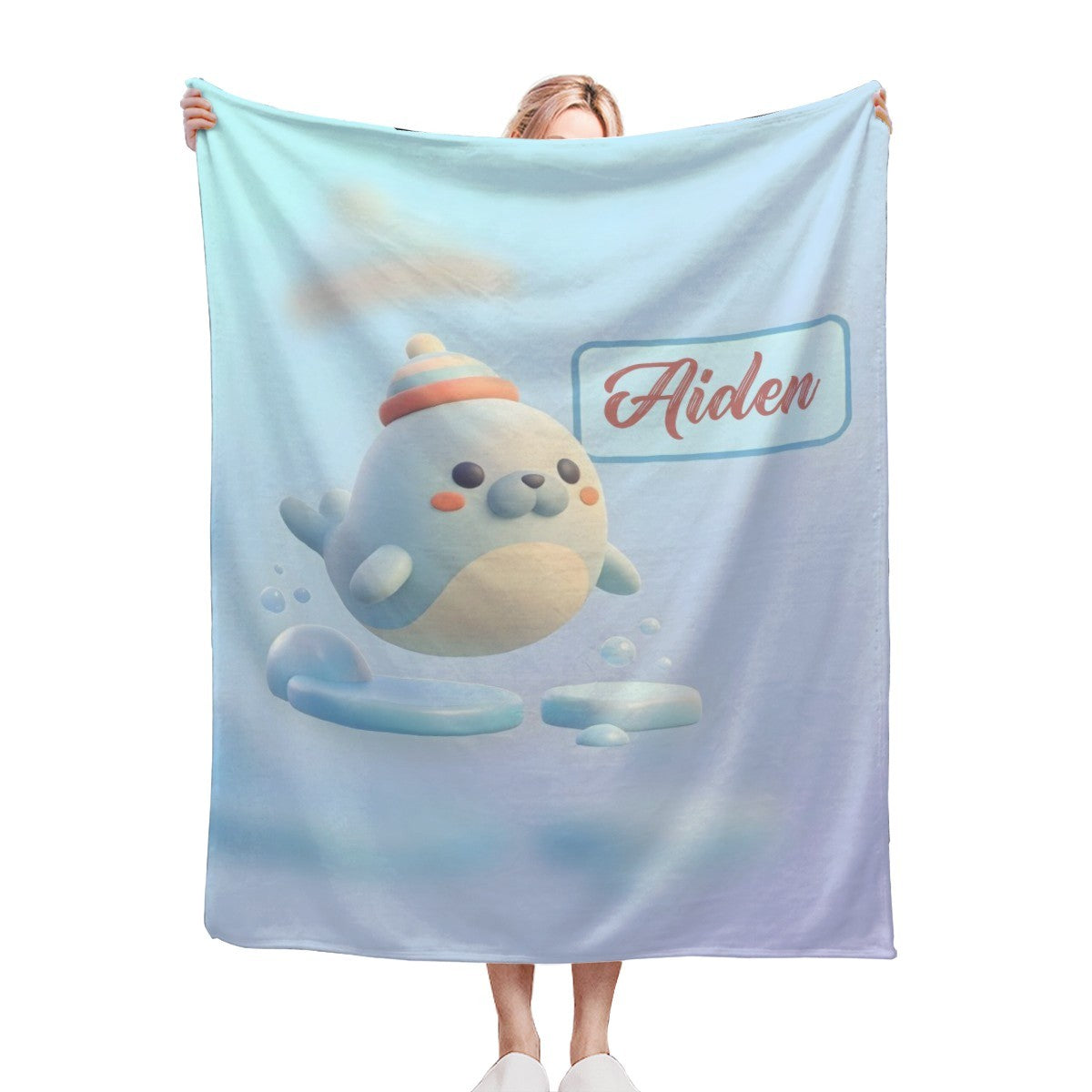 Light blue plush blanket with seal character and “Aiden” logo