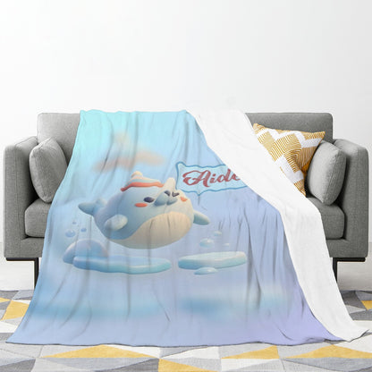 Light blue plush blanket draped over a sofa with seal character print