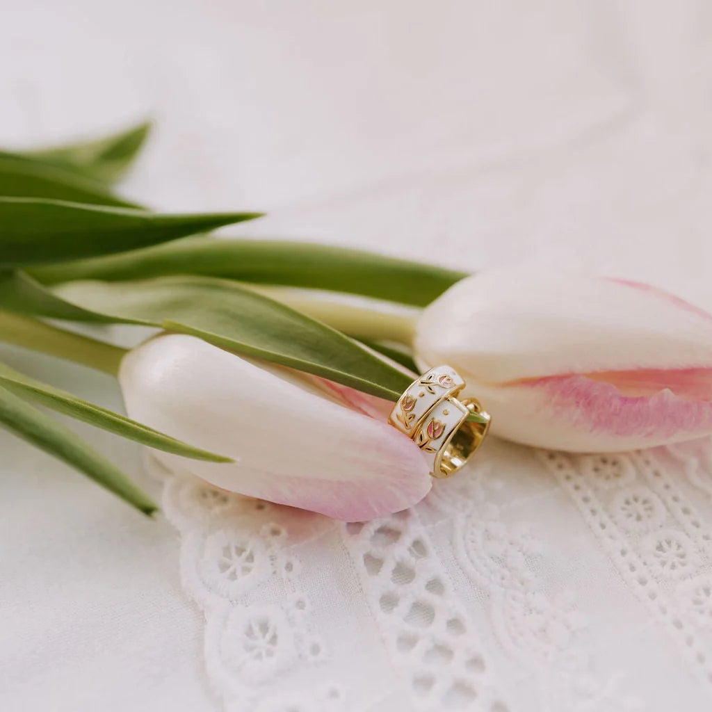 Gold enamel huggie hoop earrings with floral motifs nestled between tulips