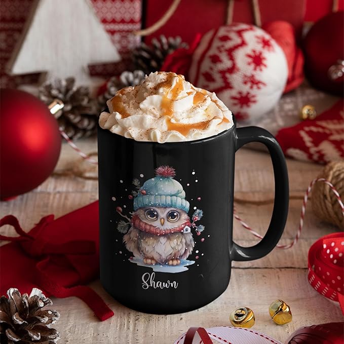 Black ceramic coffee mug with winter owl graphic and 'Shawn' name, on wooden table