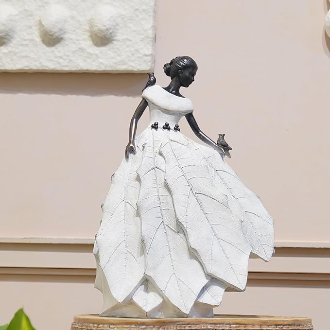 White resin fairy maiden statue standing on base with layered skirt and bird figure