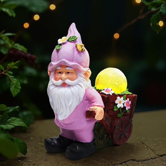 Pink garden gnome statue holding crackle glass globe lights and a flower cart