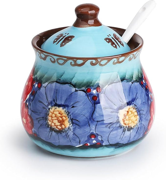 Glazed blue ceramic sugar bowl with lid and spoon, hand-painted flowers and vines