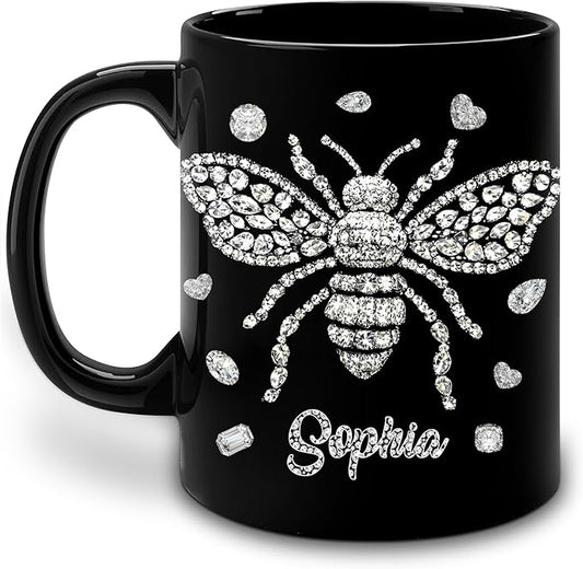 Black ceramic coffee mug with rhinestone-style bee and heart accents, name Saphia