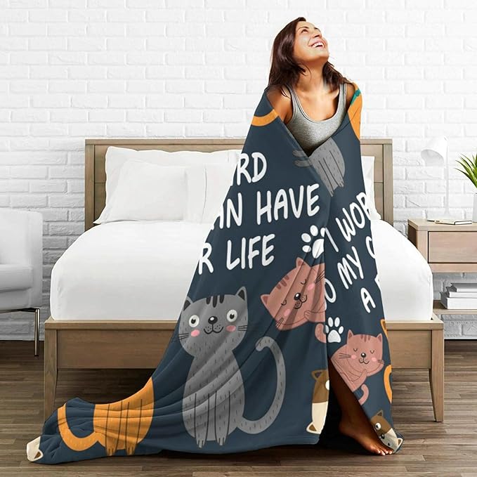 Cat throw blanket draped on bedding, dark design with cartoon cats and paw prints