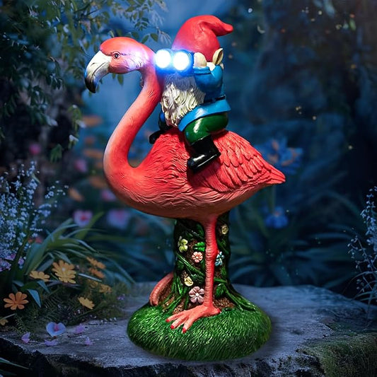 Flamingo solar garden gnome statue with glowing blue lantern on a green base