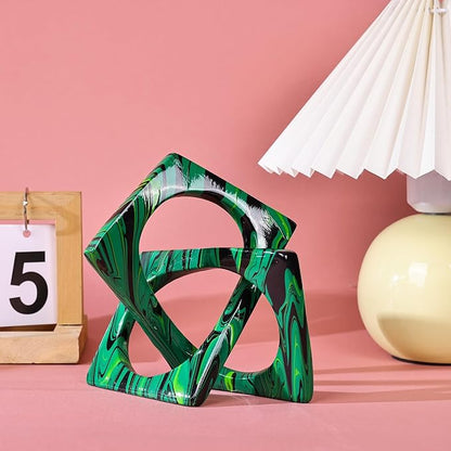 Abstract knot sculpture in glossy green and black marbled resin, with open geometric loops