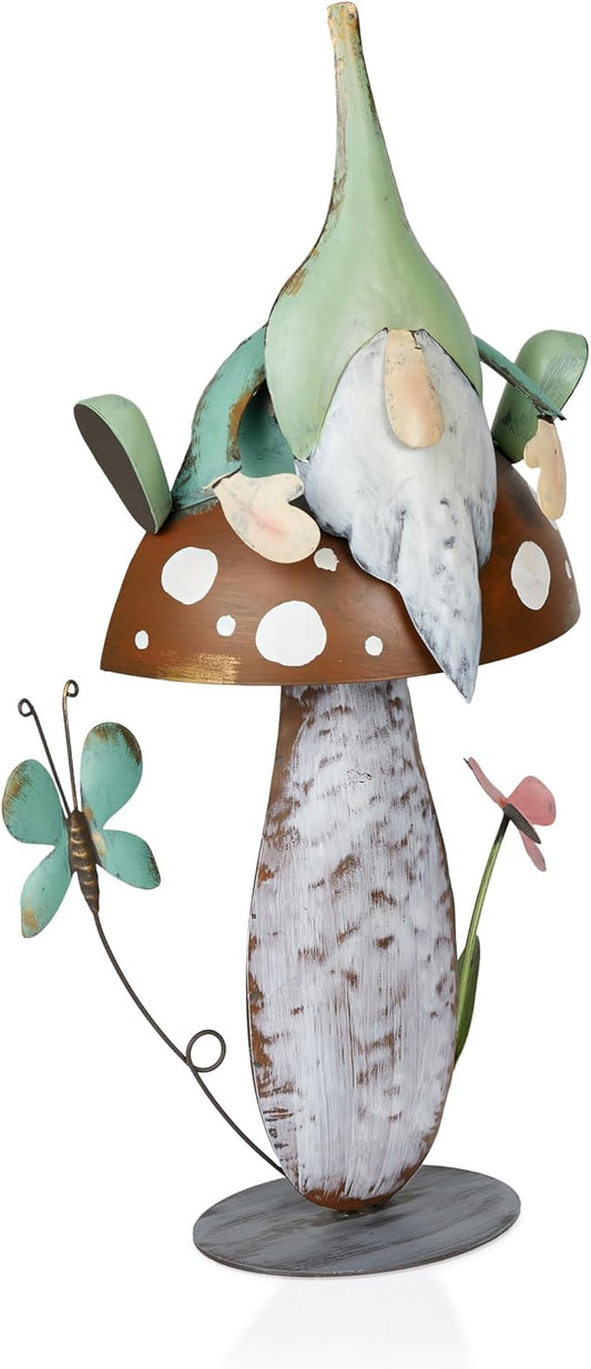 Metal gnome garden statue with green cap, white beard, brown spotted mushroom base, winged details