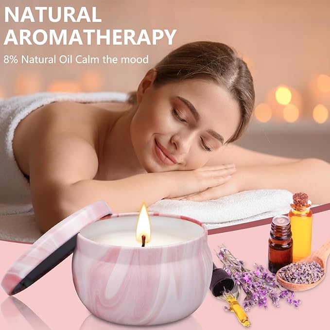 Pink marbled soy candle with flame; essential oil bottles and lavender sprigs beside
