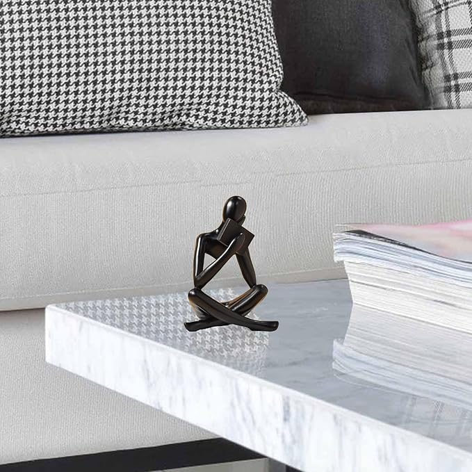 Black resin seated reading abstract figurine, low side angle