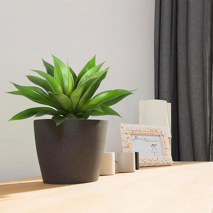 Green faux agave plant with spiky leaves in a dark pot