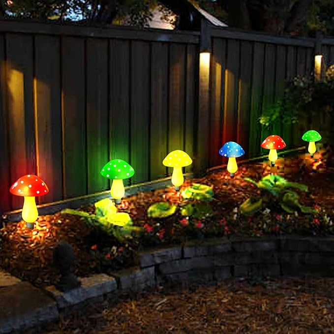 Row of glowing solar mushroom LED lights along a garden path and fence