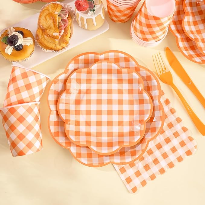 Orange and white gingham paper plates, napkins, and fork on a party table