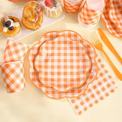 Orange and white gingham paper plates, napkins, and fork on a party table