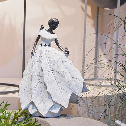 White resin fairy maiden statue in side view with layered dress and raised bird hand