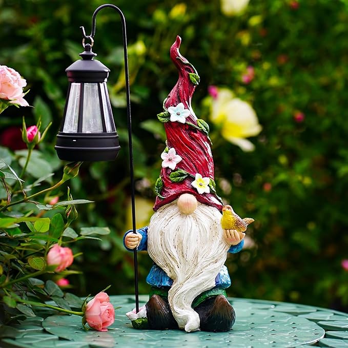 Solar garden gnome statue with red hat, white beard, holding a black lantern stake